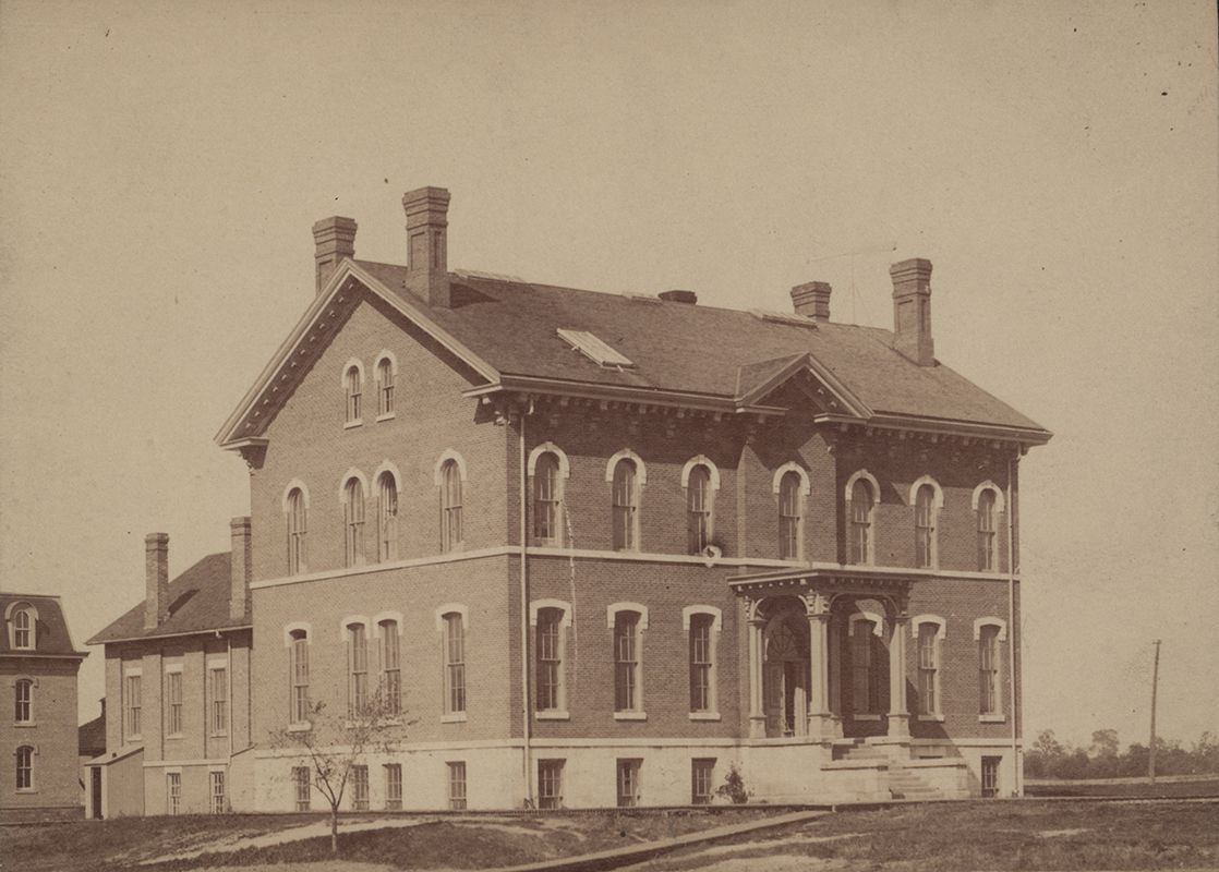 Photograph of the Chemical and Physical Laboratory in 1888. The side and front of the building are visible. It is a two-story brick building with four visible chimneys.