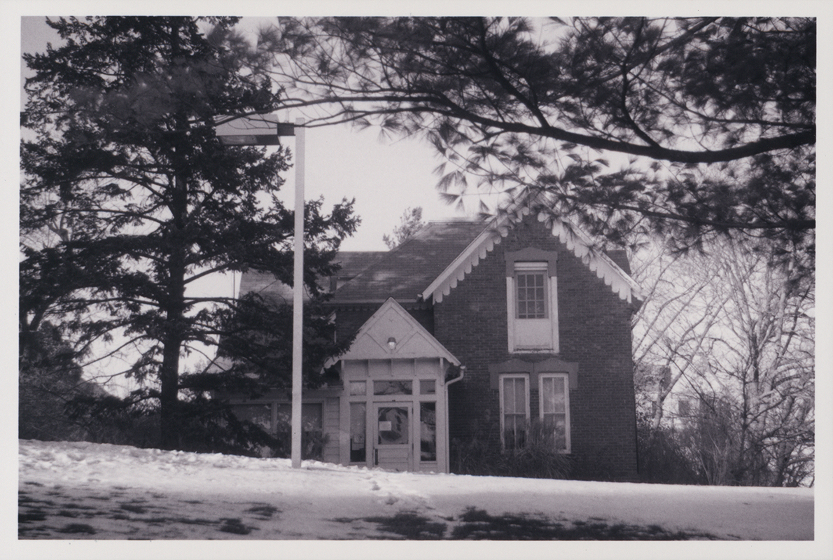 Photograph looking north at the front door of Osborn Cottage with snow on the ground.