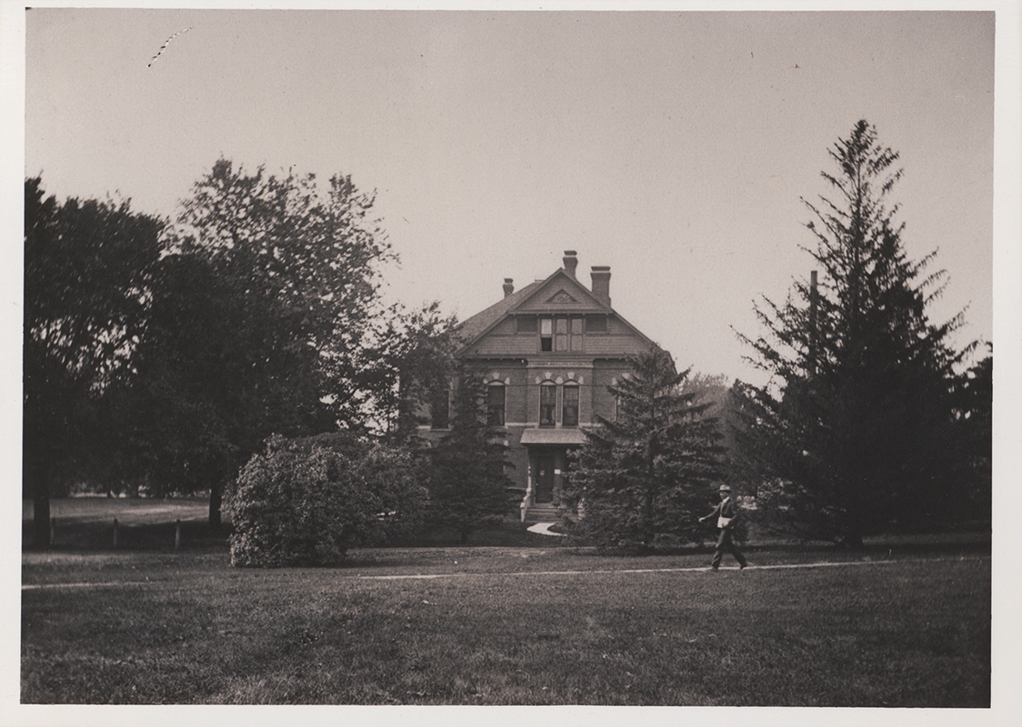 Photograph of a person walking in front of the English Office building.