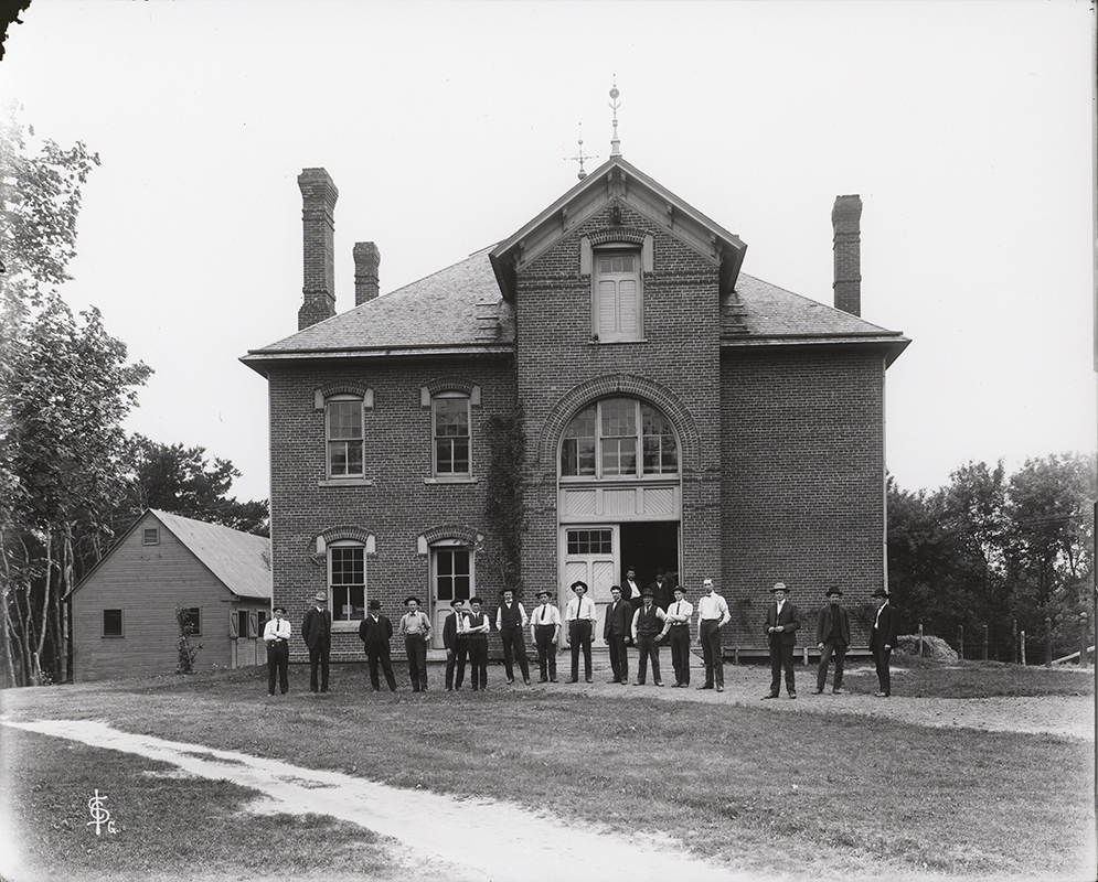 Photograph of the 1905 senior class standing outside the north side of the Veterinary Hospital. Annotation: ''Veterinary Hospital senior class May 24, 1905.''