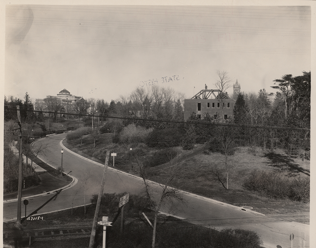 Photograph looking north at the dismantling of the Veterinary Hospital. Beardshear Hall can be seen to the north-west (left), and the Campanile can be seen to the north (rising behind the Veterinary Hospital).