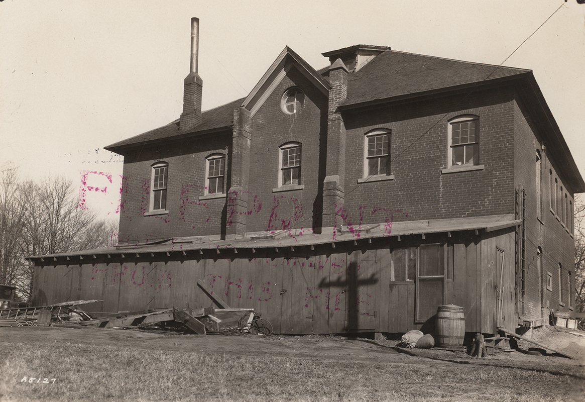 Photograph showing the west side of Veterinary Hospital including the attached storage shed.
