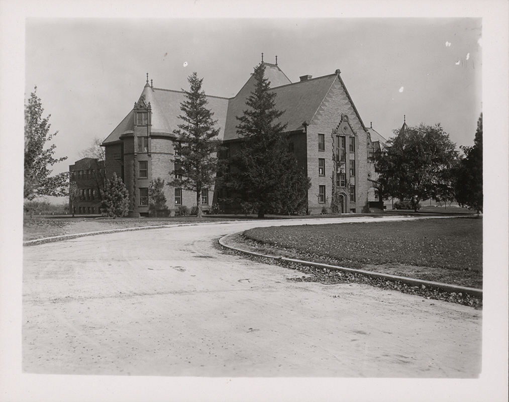 Photograph of the south and west side of Margaret Hall. A little bit of MacKay Hall can be seen to the north (right) of Margaret. Annotation: ''Margaret Hall, built in 1895. A little bit of the first Home Ec. building is visible in back. It was built in 1912.''