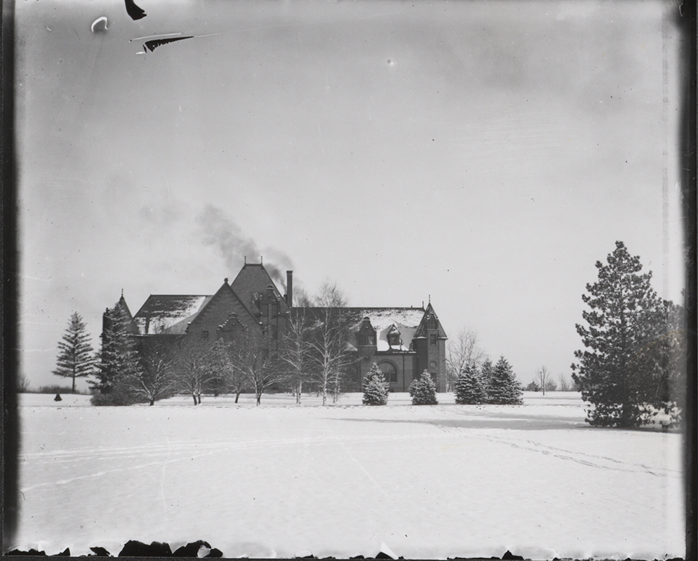 Photograph showing the south side of Margaret Hall with some snow on the roof and the ground covered with snow. Annotation: ''Dr. Spinney's collection.''