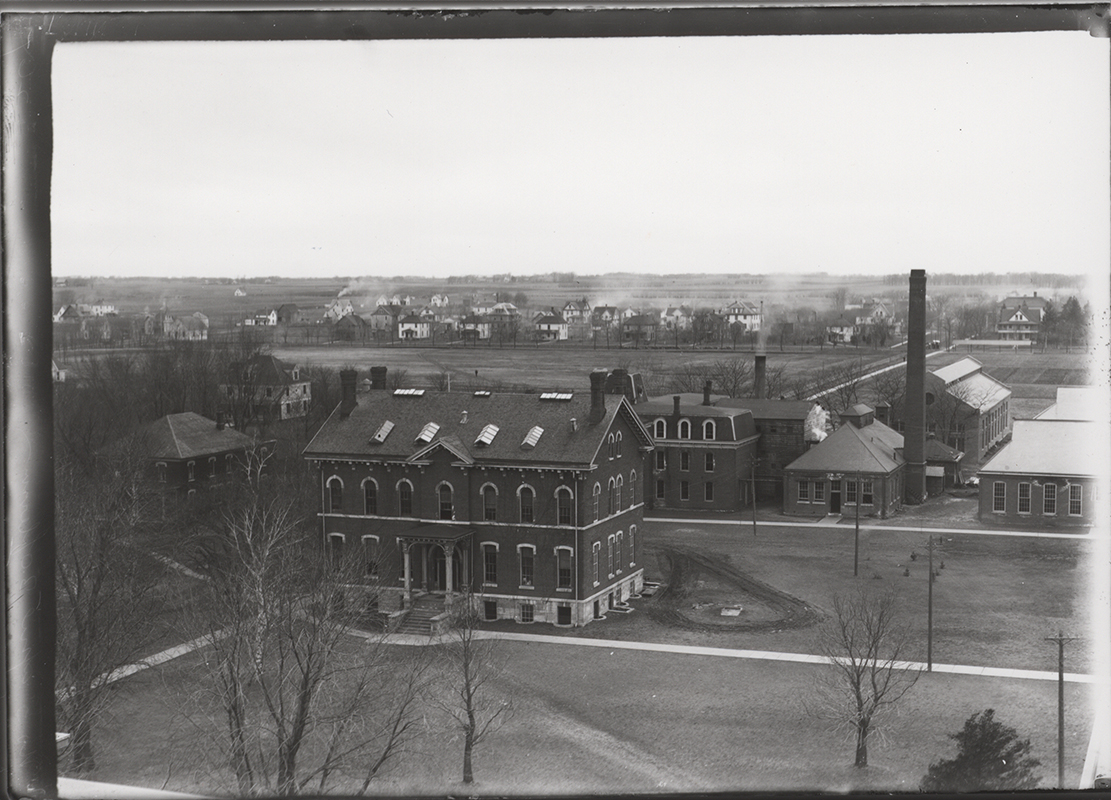 Photograph of the Chemical and Physical Laboratory taken from Bearshear Hall. The West Boarding Cottage can be seen to the southwest (left). The Laboratory of Mechanics, Power Station, Machine Shop, and Building A can be seen to the west (right). Annotation: ''(Sheldon Ave); Lincoln Way north; Quarantine Hospital?; Lab of Mechanics; Mech Eng Lab (west section completed 1908); Power Station; Bldg. A (foundry); view from Beardshear looking SW btwn (1908-1913); White House(?); Chemical & Physical Hall; Boarding Cottage (West).''