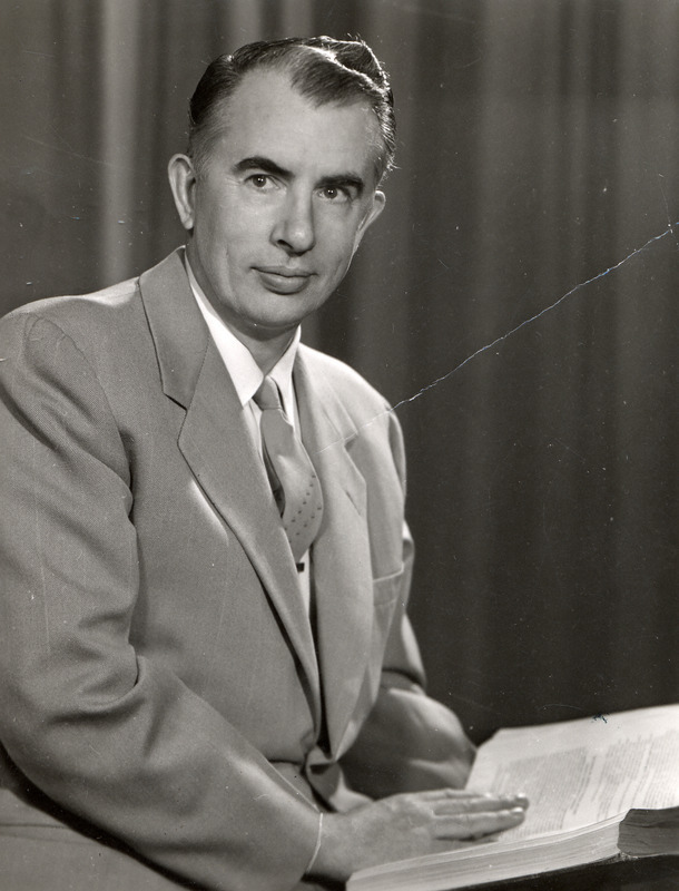 Robert W. Orr, Professor and Director of Libraries, has his hand on an open book in this portrait taken in 1954.