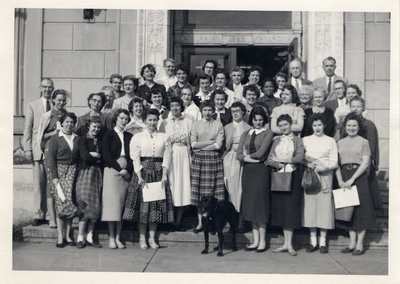 The library staff from 1955 is posed in front of the east side of the library building. They are: front row (left to right): Dorothy Redfield, Dorothy Parek, Mary Lou Johnson, Nancy Currie, Louise Hobbs, Elaine Zimmerman, Evelyn Tirado, Miriam Oliver. Second row (left to right): Patricia Ponce, Josephine Pulsifer, Beverly Van Fossen, Martha Schrei, Mary Tremmel , Joan Scanlon. Third row (left to right): Grant Hanson, Evelyn Wimmersberger, Marjorie Smith, Irene Wirth, Lois cox, Beverly Samuelson, Jean Cross, Madona Mestdagh, Beverly Speicher, Mildred McHone. Fourth row (left to right): Mildrew Brown, Dorothea Hunt, Shirley Camp, Ruth Richardson, Helen Mickefoose, Myrtle Davis, Fancis Warner, John McNee, Elizabeth Windson. Fifth row (left to right): Beverly Zimmerman, Catherine Burkiholder, Grace Oberheim, Joan Davis, Sara Koepp, Charles H. Brown, Robert W. Orr.