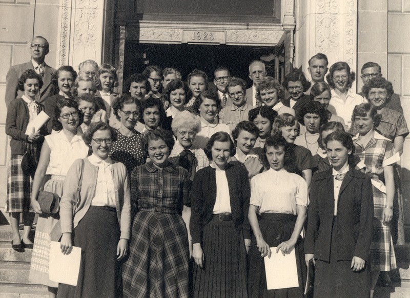 The library staff from 1952 is posed in front of the east side of the library building. The identified staff members are: Row 1 (left to right): Dorothy Havlik, Ione Miller, Roselyn Baher, Dorothy Van Bogart, Arlyn Storvick. Row 2 (left to right) Dorothy Allen, Josephine Pulsifer, Francis Warner, Constance Hauser, Jane Dobbs, Helen Baum. Row 3 (left to right) Arlyn van Ploeg, Angeline Dye, Janice Burright, Anna Young, unknown, Patricia Broker. Row 4 (left to right) Muriel Boedecker?, Dorothea Hunt, Robert Gilpatrick, Mildred Brown, unknow, Sonje Ellingboe, Ruth Kristofferson. Row 5 (left to right): Arlene James, Madonna Mestdagh, Mary Alice Baseman, unknown, Mildred McHone, John McNee, May Williams, Leona Borchers. Row 6 (left to right) Grant Hanson, Evelyn Wimersberger, Grace Oberheim, Charles H. Brown, Robert W. Orr, Bob Havlik.