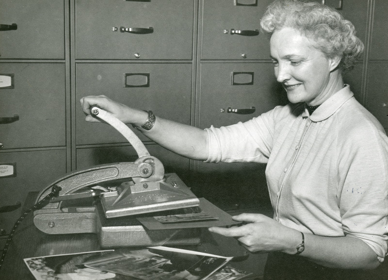 Mrs. Dorothy Kehlenbeck, curator of the College Historical Collection is using a dry mounting press.