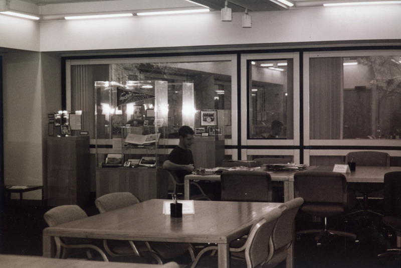 Jeff Brown, a student employee for special collections is seated at a table covered with various papers and documents.