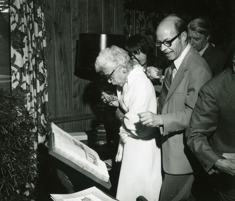 Guests at the one millionth book celebration are examining the volume.