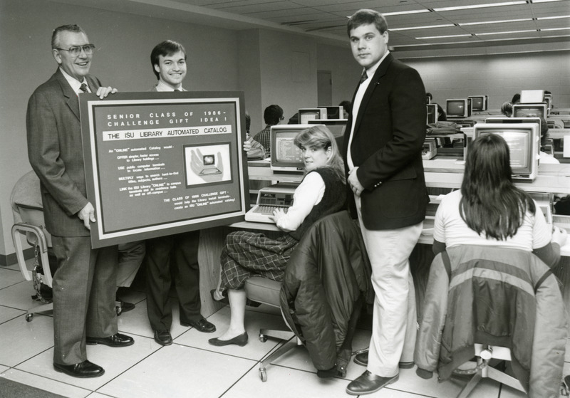 The class of 1986 gave the library its first automated catalog system. Dean Warren Kuhn and the senior class representatives are holding the class memorial in the foreground, while there are several banks of computer terminals in the background.