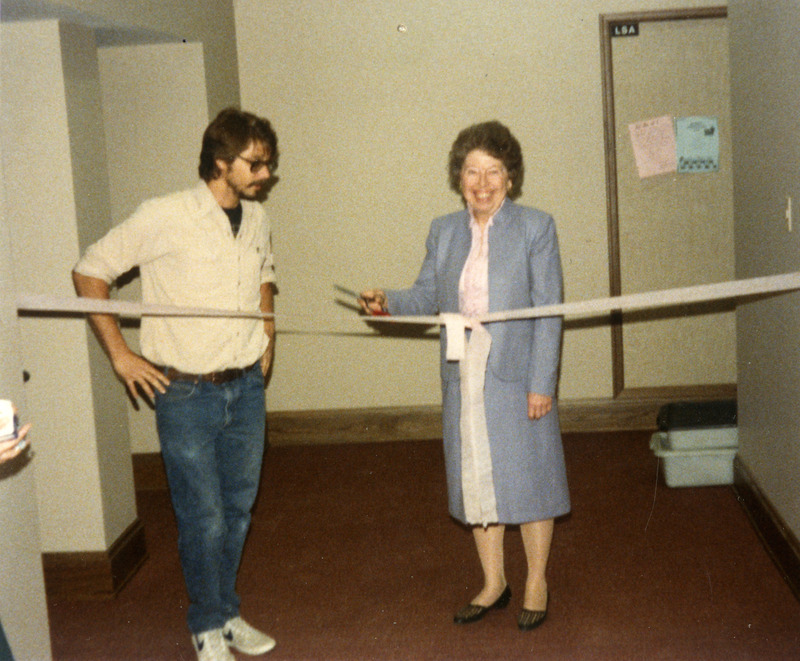 LSA President Mark Anderson and Margaret Mae Gross participate in the ribbon cutting for new staff lounge, Margaret Mae Gross is holding a pair of scissors.