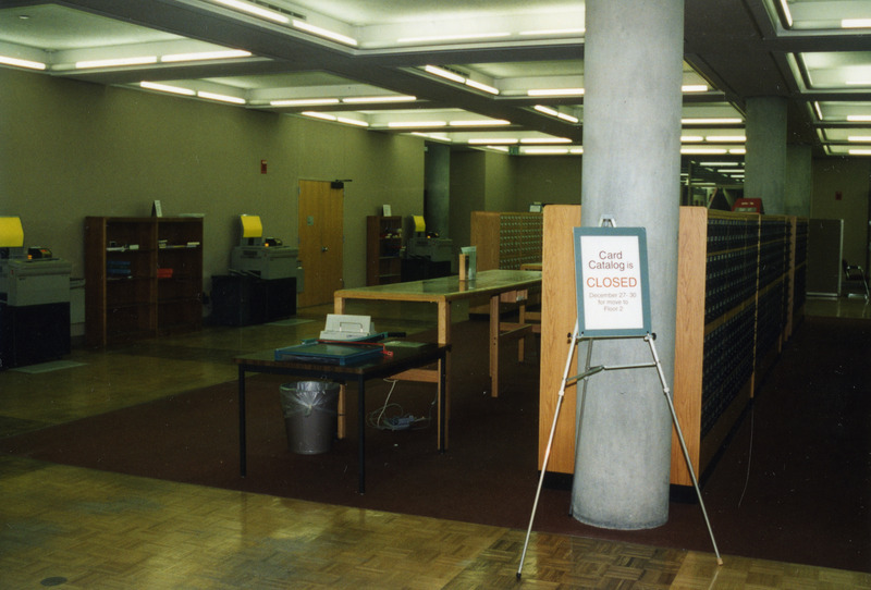 A sign reads "Card catalog is closed December 27-30 for move to Floor 2" in front of the card catalog on first floor.