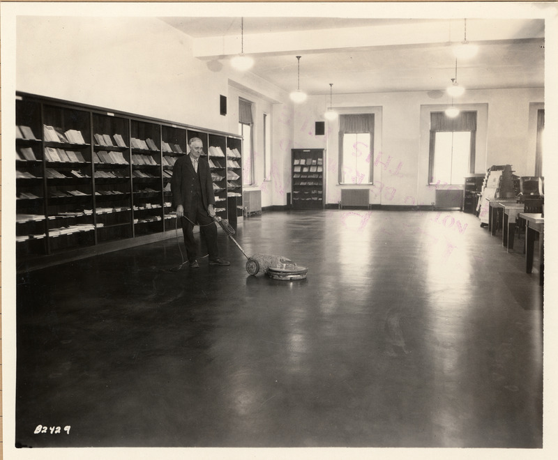 Mr. Roe operates a floor waxer in the Periodical Reading Room (currently called the Bookends Reading Room).