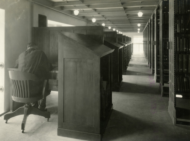 A man sits at a study carrel in the stacks (now called tiers) in the newly opened library.