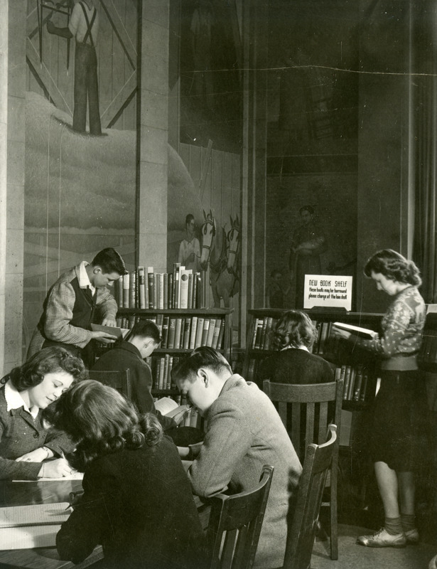 Students peruse books in the New Book Shelf area.