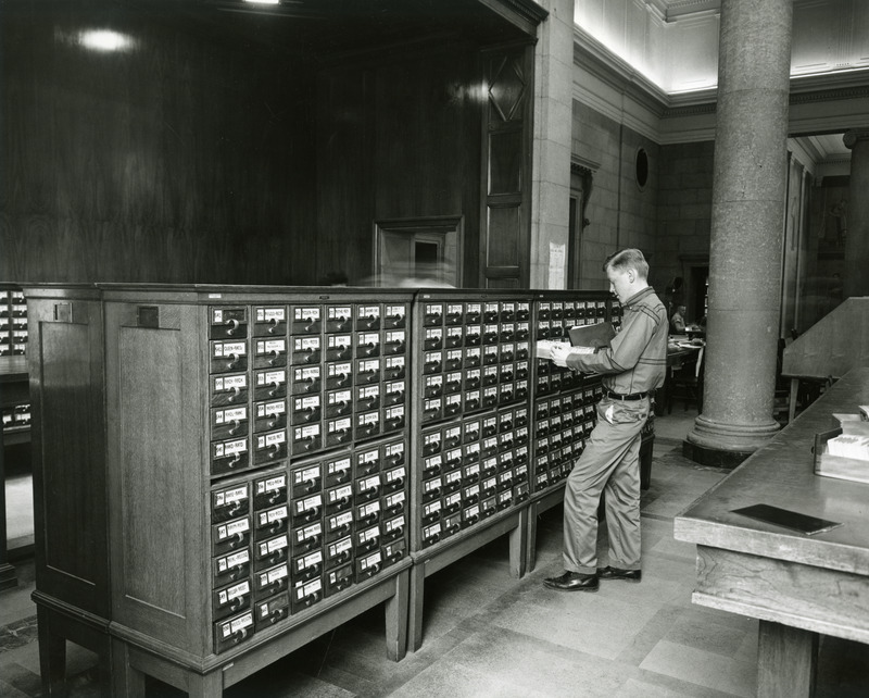 A male student browses in the library's card catalog.