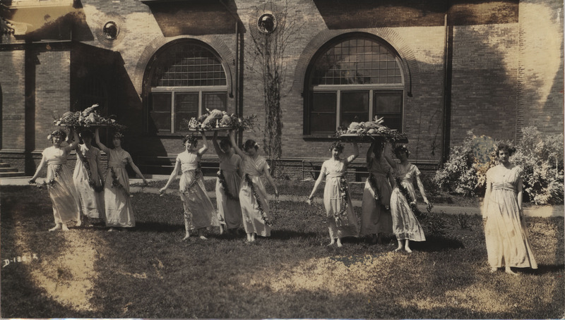 Black and white photograph of women holding platters of food during a May Day celebration in 1918 at Iowa State College.