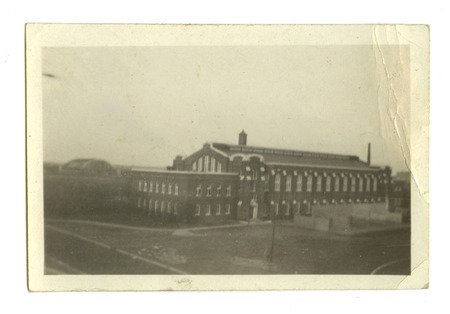 In this southwest view of State Gymnasium, Marston Water Tower is visible in the center and the Armory is on the far left. Handball courts are located outside the building.