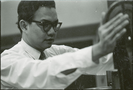 Professor Bautista examines a tubular piece of equipment.