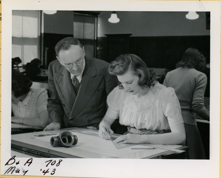 A professor is watching a cadette use a right triangle to draft a picture of a piece of equipment.