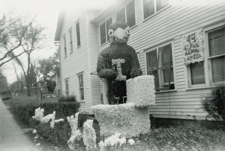 A large cardinal figure is using a toilet plunger to flush a Jayhawk down a toilet. Only the Jayhawk's legs and feet are protruding from the toilet bowl. A sign near the display read, "Alpha Kappa Lambda.".