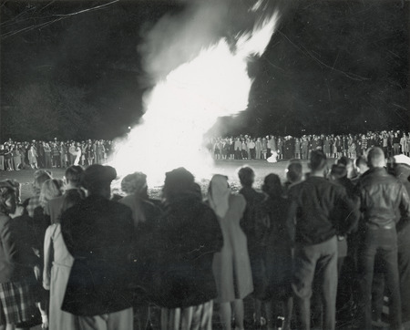 Students are gathered around a bonfire at the Homecoming Pep Rally.
