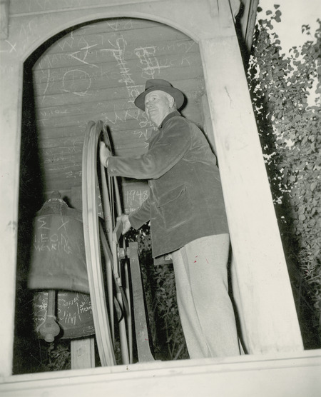 Tom Gidley, an alumnus from Malvern, Iowa rings the Victory Bell after the win over Colorado at Homecoming 1948.