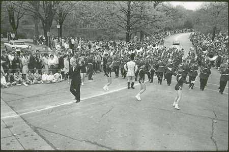 The Iowa State marching band in the 19673 VEISHEA parade. Frank Piersol, Director of Bands, walks ahead of the band, the drum major and four baton twirlers.