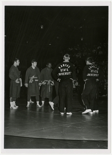 Dan Gable (second from the left) and other Iowa State University wrestlers face off against Kansas State University, circa 1970.