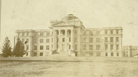 The front of Beardshear Hall shortly after completion. No landscaping for the building has yet been installed. A field of short grass is shown in front of the building. No street or sidewalk can be seen.