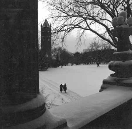 The Campanile in winter as seen from the portico of Curtiss Hall. A trail through the snow toward the Campanile can be seen with two people midway and centered in the photograph. One of a set of two photographs, the other being: 4-8-I.Campanile.230-7-3-1.