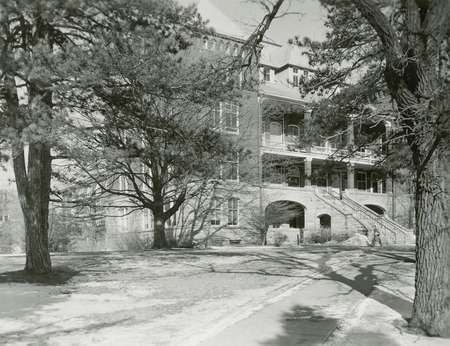 A view of Catt Hall from the path. Trees obscure portions of the building, as an individual.