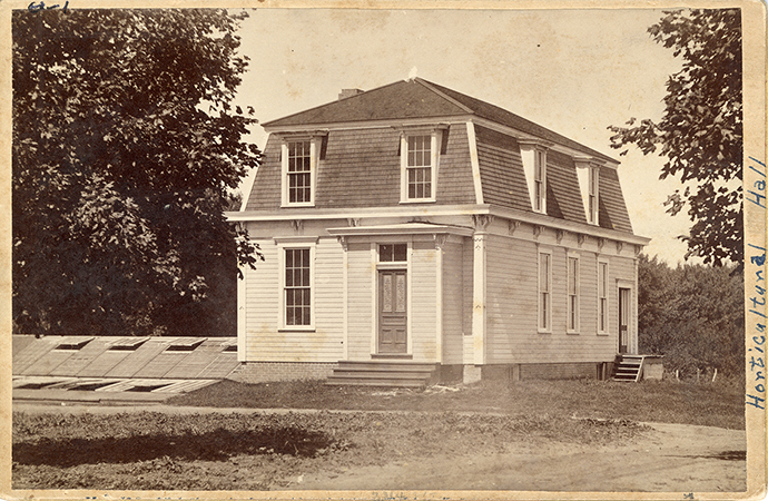 Photograph of the Farm Boarding Club when the building was located on Morrill and was known as Horticulture Hall. Annotation: “Faculty Club stood where Library is now. Farm Boarding Club.”
