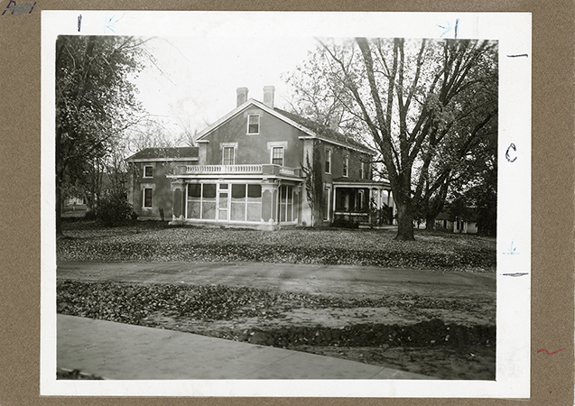 Photograph showing the south-west corner of the Farm House including both the west and south porches. The Creamery, First can be seen in the background to the right (west) of the Farm House. Annotation: “The Farm House, picture appears in 1915 Alumnus.”