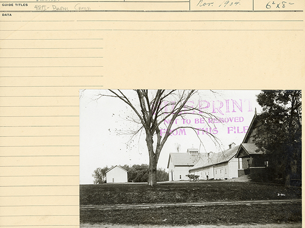 Photograph showing the Cattle Barn, the Horse Barn, and farm area, looking north-northeast. A person walks with two horses beside the barn.