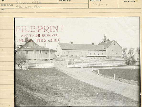 Photograph of a west-northwest view of the barn complex. It shows the horse and cattle barns, a pavilion, and an outbuilding, with fenced pastures in the foreground.