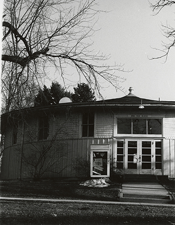 Photograph of the Shattuck Theatre showing the exterior south doors and a signboard containing a poster for "Fiddler on the Roof."