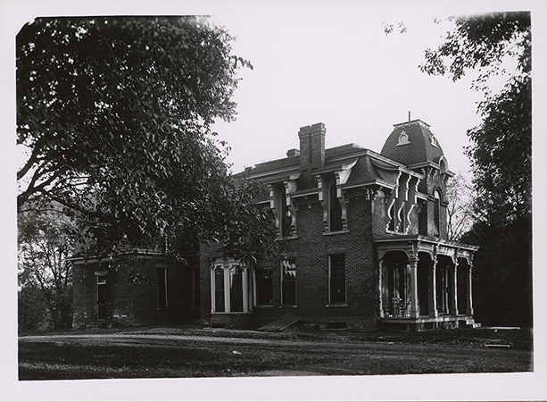 Photograph of South Hall on the Iowa State campus, showing the north and west elevations. The view is looking south-southeast. The image depicts a large brick building with a covered porch, partially framed by trees. Annotation: "Music Hall (Old South Hall), burned in 1912. South Hall. neg no 009597."