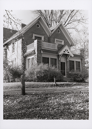 Photograph of Old Music Hall, showing the south and west elevations of a two-story brick building with balconies. The building is surrounded by trees. Annotation: "Old Music Hall. n.d. no neg b/w."