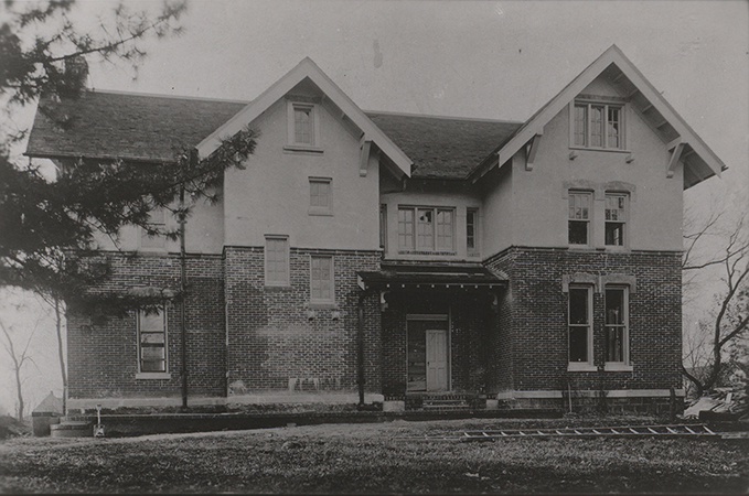 Photograph of International House. Several windows are broken and there is a ladder in the front yard.