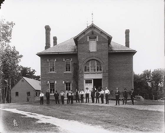 Photograph of the 1905 senior class standing outside the north side of the Veterinary Hospital. Annotation: ''Veterinary Hospital senior class May 24, 1905.''