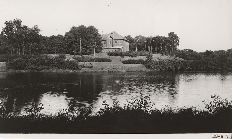 Photograph looking across Lake LaVerne at the west and south sides of the Veterinary Hospital. Annotation: "Old Carpenter & Paint Shop on site of M.U. Formerly the Veterinarians' Hospital, this structure was torn down in 1927."