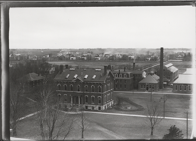 Photograph of the Chemical and Physical Laboratory taken from Bearshear Hall. The West Boarding Cottage can be seen to the southwest (left). The Laboratory of Mechanics, Power Station, Machine Shop, and Building A can be seen to the west (right). Annotation: ''(Sheldon Ave); Lincoln Way north; Quarantine Hospital?; Lab of Mechanics; Mech Eng Lab (west section completed 1908); Power Station; Bldg. A (foundry); view from Beardshear looking SW btwn (1908-1913); White House(?); Chemical & Physical Hall; Boarding Cottage (West).''