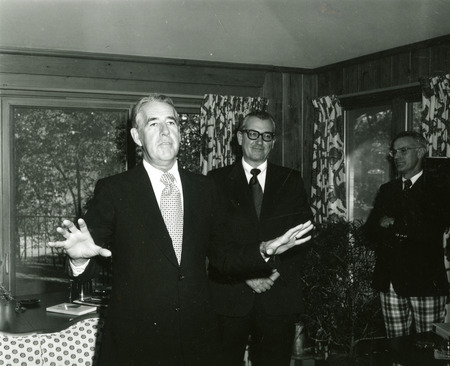 William Robert Parks is discussing the celebration of the library's purchase of the one millionth book, Other library staff members are in the background.