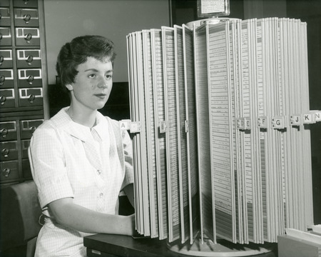 Ann Page, library office receptionist, works at the periodical kardex file.
