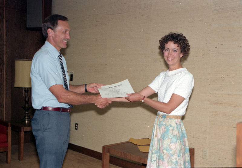 Photograph of Susan Kirschner receiving her residency certificate from Dan Betts