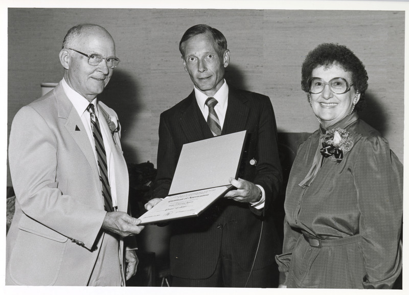 Photograph of Dean Pearson handing Ron Moses a certificate of appreciation during his retirement reception
