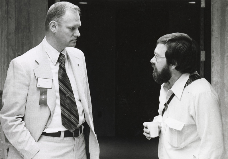 Photograph of John Greve speaking with an attendee of the 1976 International Pig Veterinary Society (IPVS) Congress at the Scheman Building